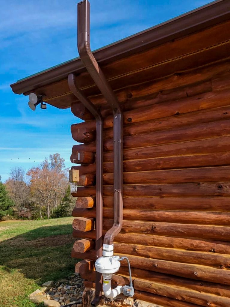Radon mitigation system on log cabin exterior for radon services
