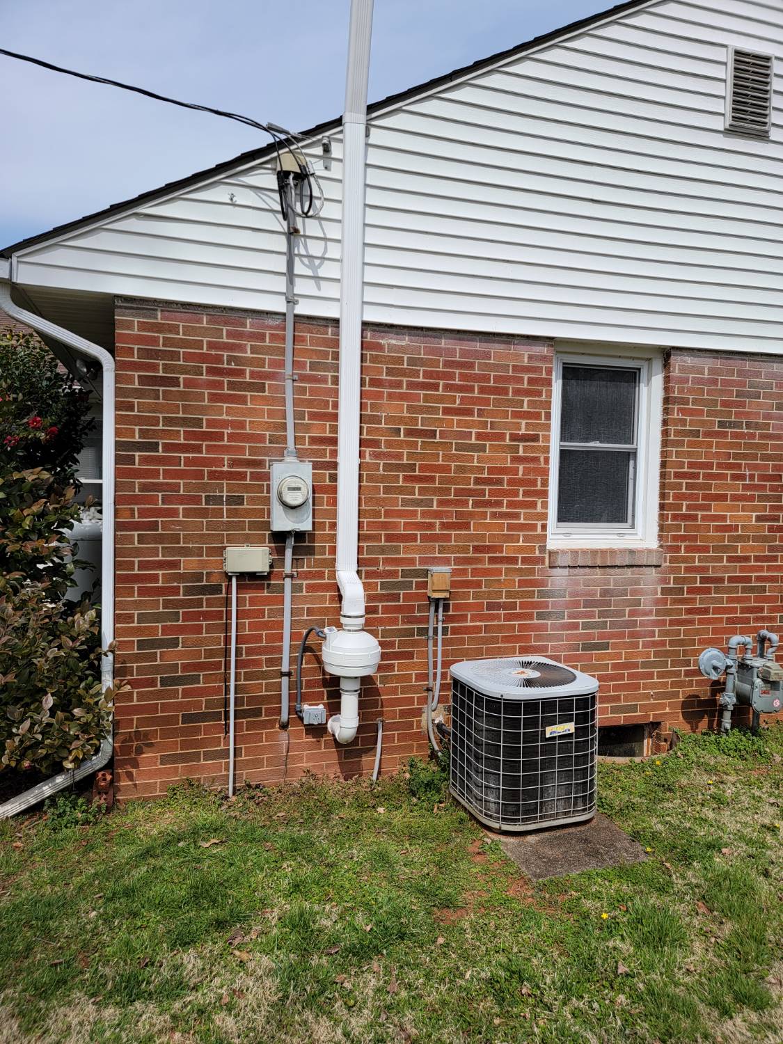 Radon mitigation system on residential home exterior
